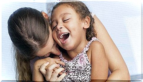 mother hugging and playing with her daughter