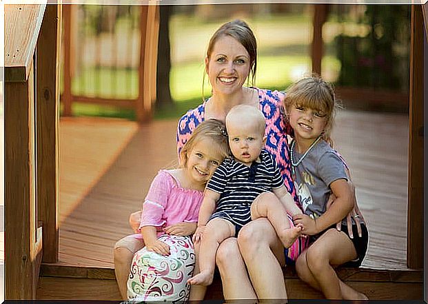 mother and her three daughters smiling and posing for a photo