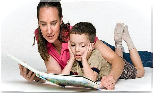 mother lying on the floor reading with her son