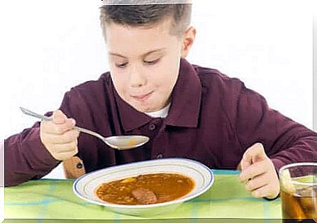 Boy eating chicken soup because he has a stomachache