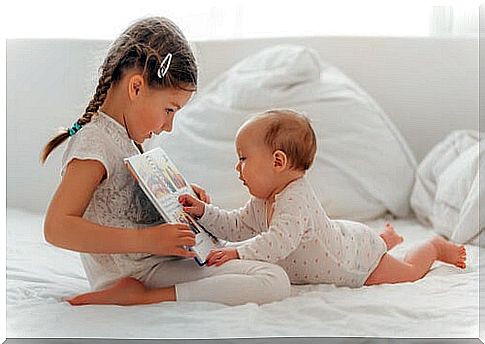 sister reading book for brother