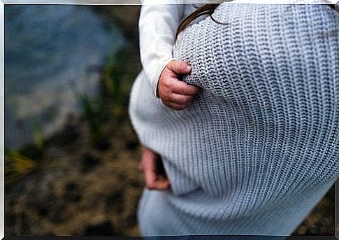 Baby on mother's lap holding her blouse